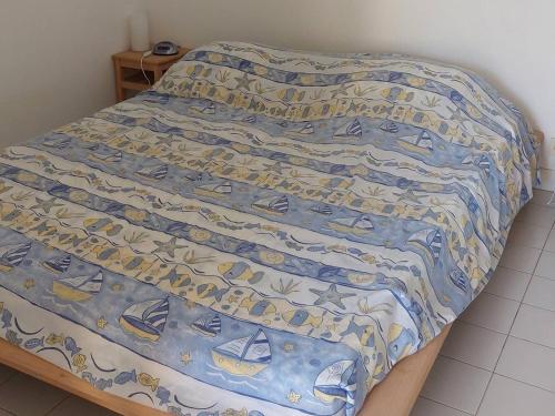 un lit avec un couvre-lit bleu et blanc avec des bateaux dessus dans l'établissement Appartement avec Jardin Privatif, Piscines, Activités Eté, Animaux Acceptés - 83380 Roquebrune-sur-Argens - FR-1-768-7, aux Issambres