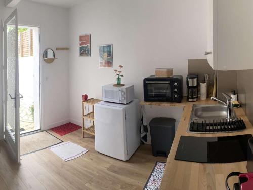 une petite cuisine avec un micro-ondes et un réfrigérateur dans l'établissement T1 Bis Charmant à Bidart, 2 Pers, 900m Plage, Terrasse et Spa, Quartier Calme - FR-1-495-137, à Bidart