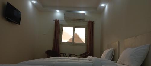 a bedroom with a pyramid seen through a window at The Heaven Pyramids View in Cairo