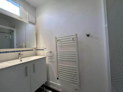 La salle de bains blanche est pourvue d'une douche et d'un lavabo. dans l'établissement Appartement La Rochelle, 1 pièce, 2 personnes - FR-1-246-687, à La Rochelle