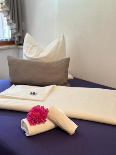 a bed with a towel and a flower on it at Ferienwohnung Vesna & Alex in Elmen