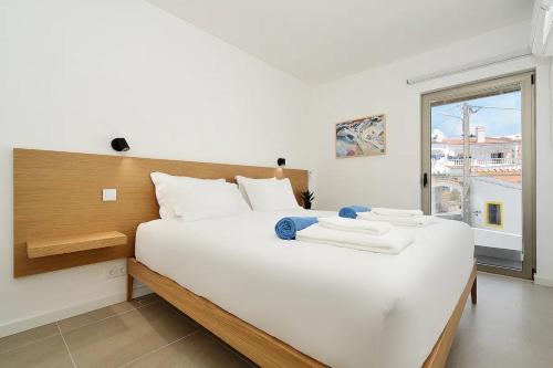 a large white bed in a room with a window at Dália modern apartment Five minutes to beach in Luz