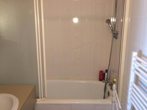 La salle de bains est pourvue d'une douche et d'une baignoire blanche. dans l'établissement Appartement rénové avec terrasse, piscine, parking, et WIFI - 6 couchages, proche commerces - FR-1-790-19, à La Grande Motte