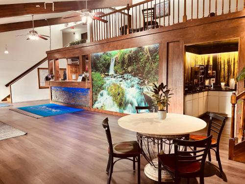 a dining room with a table and a waterfall mural at Travelodge by Wyndham Valleyfair Shakopee in Shakopee
