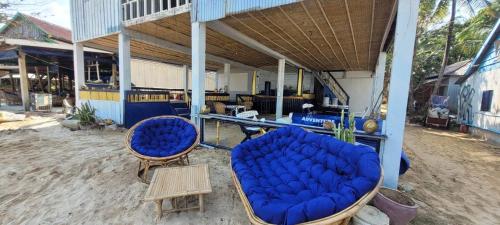 a porch with two blue chairs and a table at CocoHuts in Koh Rong Sanloem