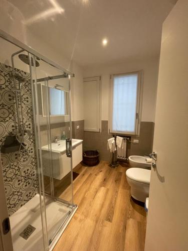 a bathroom with a shower and a toilet and a sink at PIO X Apartments Treviso in Treviso