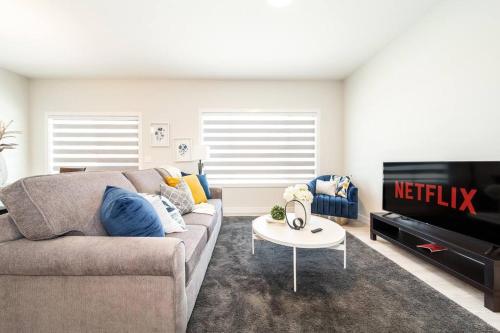 a living room with a couch and a tv at Beautiful Elegant Home Sleeps 10, Free Parking, Central AC in Edmonton