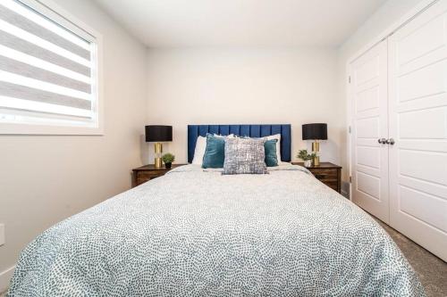 a bedroom with a large bed and two lamps at Beautiful Elegant Home Sleeps 10, Free Parking, Central AC in Edmonton
