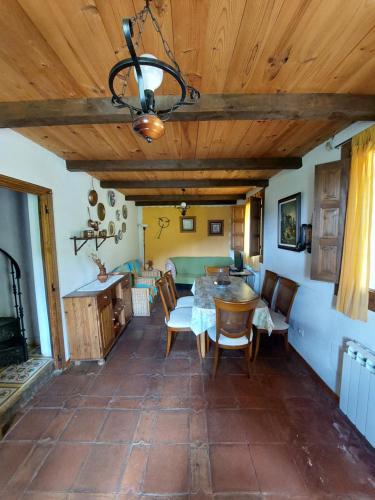 a kitchen and dining room with a table and chairs at Las Peonías Casa Rural in Almiruete