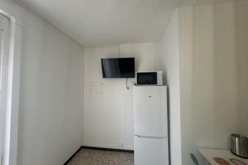 Elle comprend un réfrigérateur blanc et une télévision. dans l'établissement 2 air-conditioned rooms in villa by the sea, à Frontignan