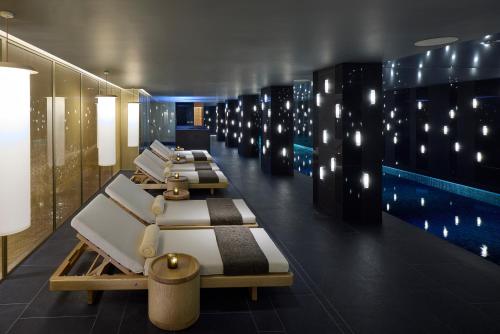 a room with a row of beds and a pool at Mandarin Oriental Mayfair, London in London