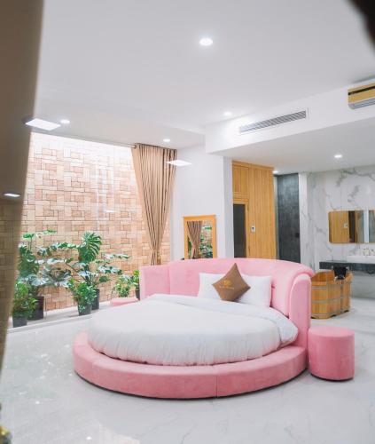 a pink bed in a living room with a pink couch at Quy Tai Premium Hotel in Da Lat