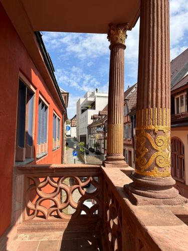 a balcony with columns on a city street at AMAO Green - City Center - Penthouse Maisonette - 90 m2 - 8 Guests - Rooftop Terrace - King-Size Beds in Lahr