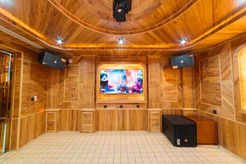 a large wooden room with a tv in the middle at Quy Tai Premium Hotel in Da Lat
