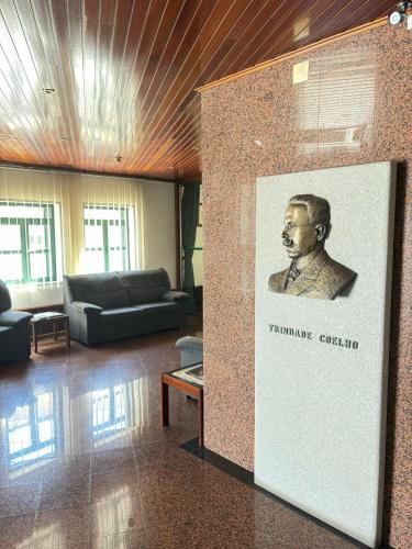 a room with a wall with a picture of a black man at Hotel Trindade Coelho in Mogadouro