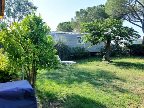 a garden with a bench and a house at Mobil Home dans camping Lattes in Lattes