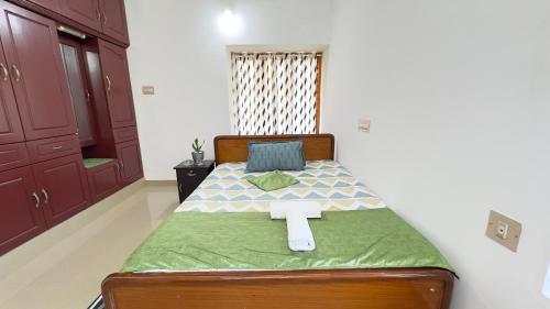 a bedroom with a bed with a cross on it at Halcyon Homes-Trivandrum in Chacka