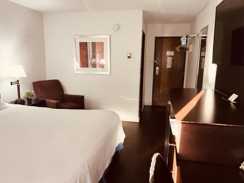 a hotel room with a bed and a chair at Travelodge by Wyndham Valleyfair Shakopee in Shakopee