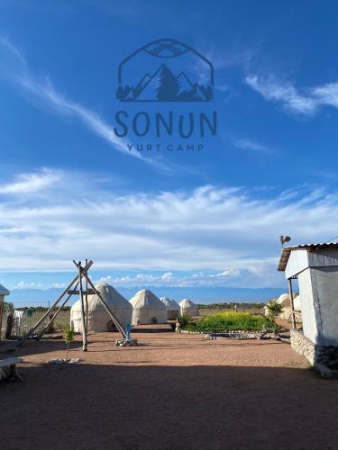 a sign that reads sonnant ut camp in front of tents at Yurt camp Sonun in Bokonbayevo