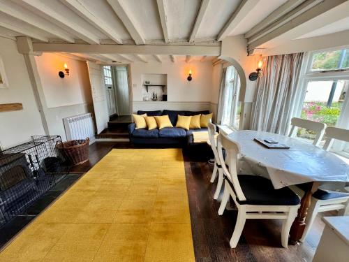ein Wohnzimmer mit einem Tisch und einem Sofa in der Unterkunft Cosy Coastal 2-Bedroom Cottage with Hot Tub and Log Burner in West Mersea