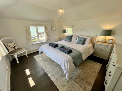 A bed or beds in a room at Cosy Coastal 2-Bedroom Cottage with Hot Tub and Log Burner