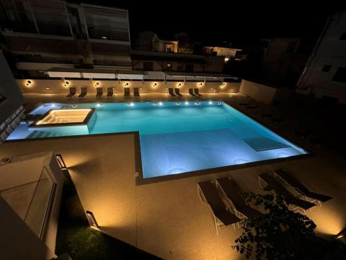 a swimming pool at night with chairs and lights at Studio Nikiti Beach in Nikiti