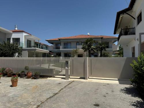 a white fence in front of a house at Studio Nikiti Beach in Nikiti