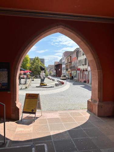 an archway over a street in a town with a fountain at AMAO-Curry - City Center - 100 m2 - 7 Personen - Balkon - 2 Schlafzimmer - KingSize Betten in Lahr