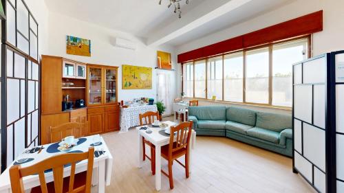 a living room with a couch and a table and chairs at La casa di Tina in Briatico