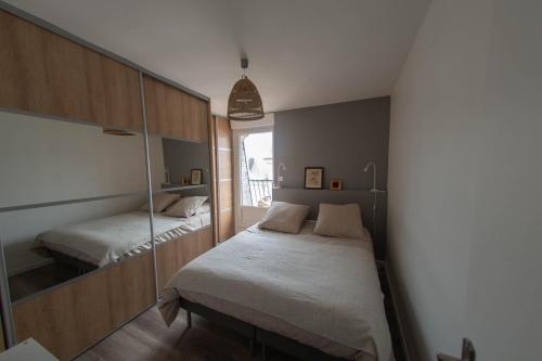 sypialnia z dwoma łóżkami i lustrem w obiekcie Appartement LE JULES FAVRE w Tours