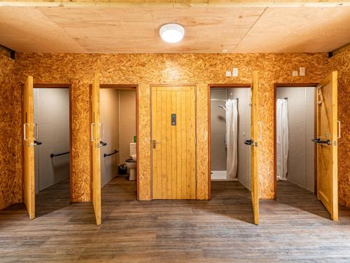 un pasillo con 4 puertas en una habitación en YHA Eden Project en Par