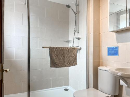 a bathroom with a shower with a toilet and a sink at Honeysuckle Cottage - 27880 in Elton