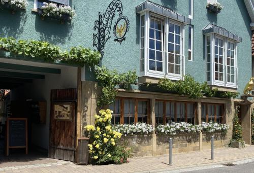 a blue building with flowers on the front of it at Adler Botenheim in Botenheim