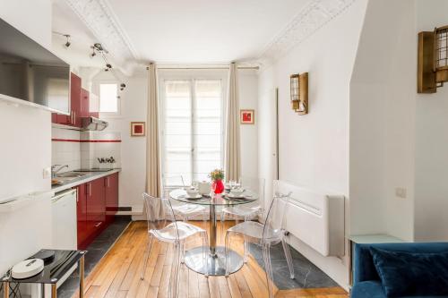 une cuisine avec une table et des chaises dans une pièce dans l'établissement Saint Paul le Marais Charlemagne, à Paris