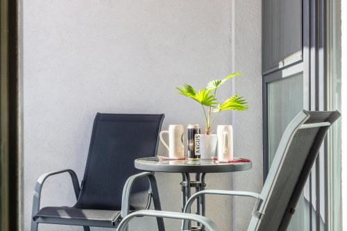 two chairs and a table with a plant on it at ARI - ARED Luxurious Apartments with Balcony & Free Parking in Arad