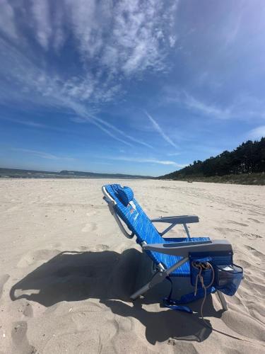 a blue beach chair sitting on a sandy beach at App 7o KleinerTag am Meer in Dranske