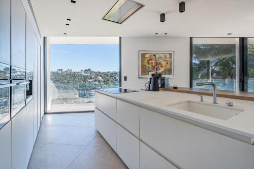 une cuisine avec un grand évier et une grande fenêtre dans l'établissement villa La Pinède, à Cagnes-sur-Mer