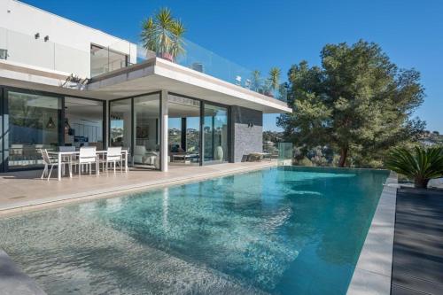 une maison avec une piscine devant une maison dans l'établissement villa La Pinède, à Cagnes-sur-Mer
