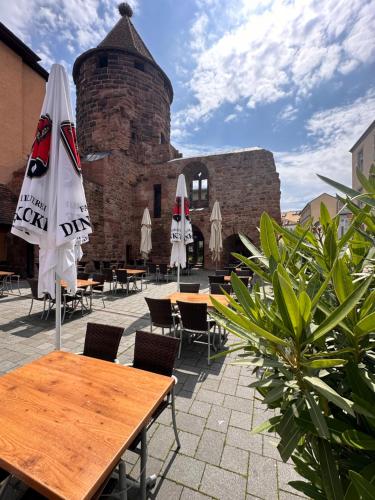 an outdoor patio with tables and umbrellas and a building at AMAO Obsidian - 120 m2 Business & Family Apartment - 3 Bedrooms - 8 Guests - King-Size Beds in Schwanau