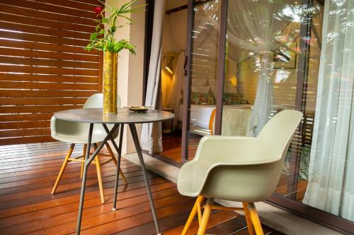 a table with two chairs and a vase on it at La Varangue in Antananarivo