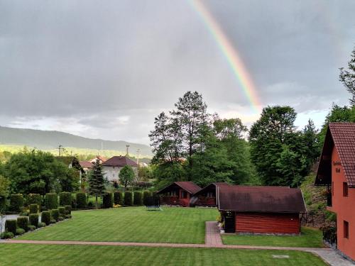 a rainbow in the sky over a house with a yard at Case de vacanță Gabriel in Sovata