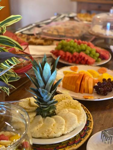a table topped with plates of food with a pineapple on it at Hotel Pousada Villa Itália Olímpia in Olímpia
