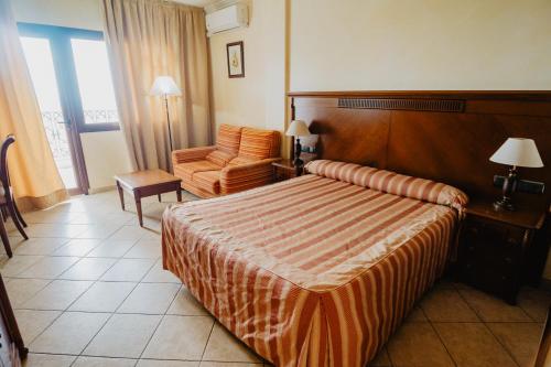 a hotel room with a bed and a chair at Hotel Hacienda Don Manuel in Granja de Torrehermosa