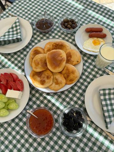 a table with plates of food on a checkered table cloth at Vila Horizont in Baks-Rrjoll