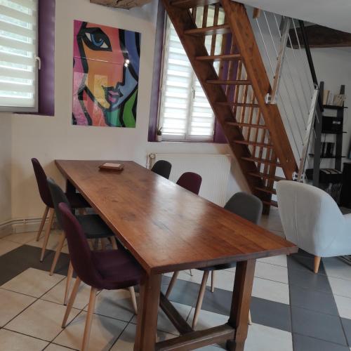 une salle à manger avec une table et des chaises en bois dans l'établissement Maison spacieuse et calme à la campagne, à Saint-Denis-sur-Sarthon