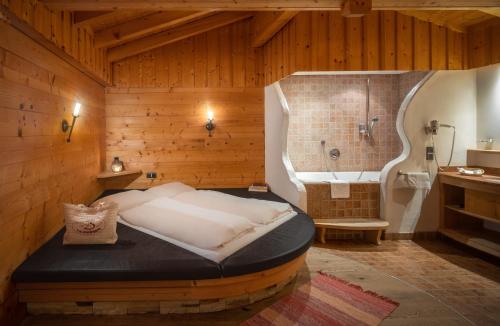 翁肯的住宿－維塔勞斯布魯登酒店，一间卧室设有一张大床和一个浴缸