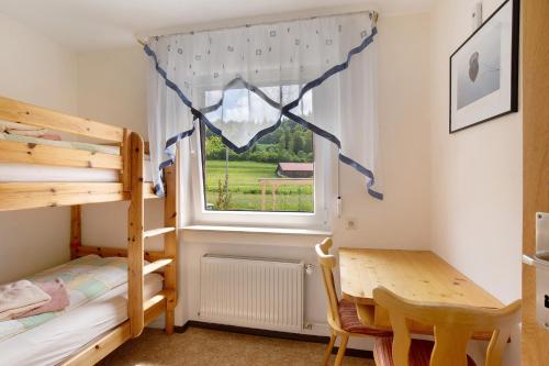 a bedroom with a bunk bed and a desk and a window at Abendrot in Münsingen