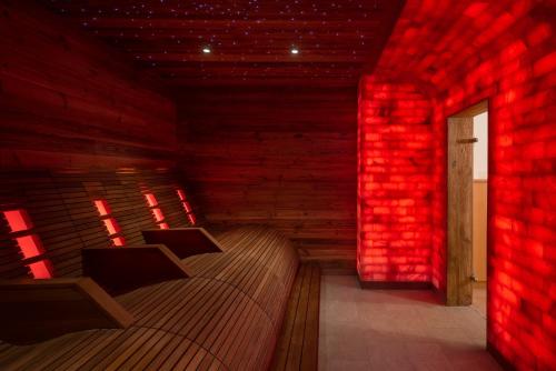 a room with a bed with red lights on it at Hotel Vitaloase zu den drei Brüdern in Unken