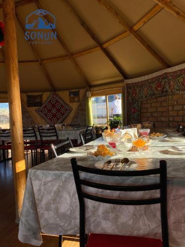 a dining room with a table with food on it at Yurt camp Sonun in Bokonbayevo