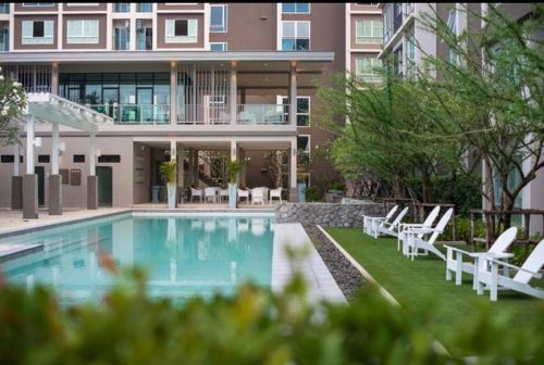 a house with a swimming pool in front of a house at 350 METER BEACH, Newly renovated Condo in Hua Hin